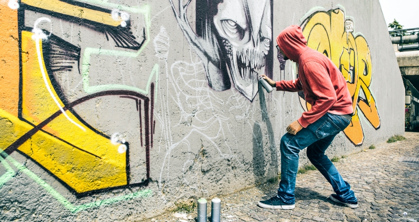 man writing graffiti on a wall